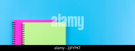 Education banner for website with two spiral notebooks on bright blue background with some blank space. Stock Photo