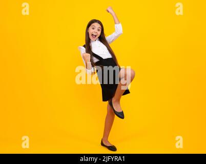 Successful winner child. Excited expression, cheerful and glad. Child with positive expression, joyful and exciting over yellow background with empty Stock Photo