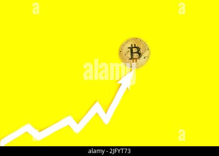 Arrow graph indicates growth of value bitcoin cryptocurrency,on yellow background Stock Photo