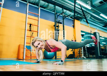 Fitness girl training trx workout in gym Stock Photo