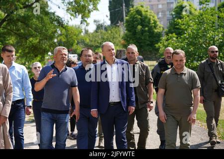 Taoiseach Micheal Martin with local officials outside the church of St Andrew the First Called in Bucha, where a mass grave was used by Ukrainians to bury neighbours they claim were killed at the hands of Russian armed forces during the invasion of Ukraine. Picture date: Wednesday July 6, 2022. Stock Photo
