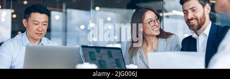 Positive business team working on new project in modern office Stock Photo