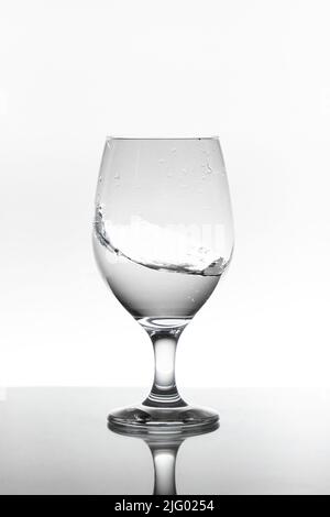 moving water inside a glass cup Isolated on white background Stock Photo