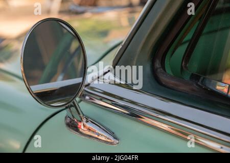 Andover, MA, US-June 26, 2022: Close-up of the outside mirror of a classic green sports car. Stock Photo