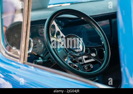 Andover, MA, US-June 26, 2022: Close-up view of the steering wheel in a bright blue classic car. Stock Photo