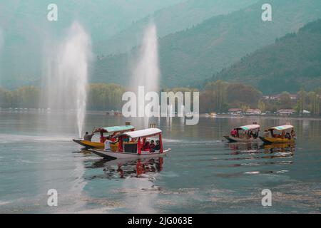 Srinagar, 10, April,2016; Reflection of colourful Shikara boats with mountains and water fountains background in Dal Lake,Srinagar, Kashmir, India Stock Photo