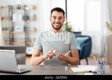 man using hand sanitizer at home office Stock Photo