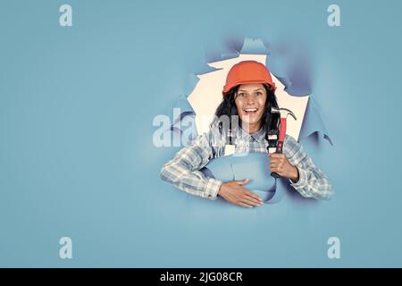 equipment for repairing. mechanic girl in protective hardhat. building and construction. professional manual worker. technician working using hammer Stock Photo