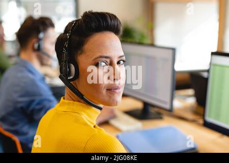 Portrait of confident caucasian female customer service executive with headset in office Stock Photo