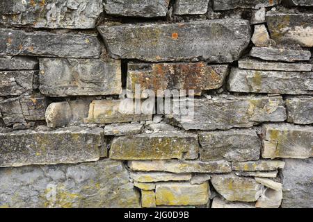 Wild stone wall background. Old castle rough stone wall texture. Stock Photo