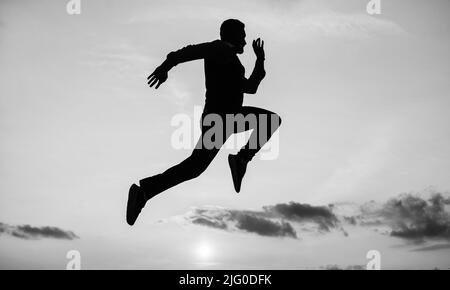 man runner silhouette running to future against sunset sky, success Stock Photo