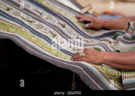 Ecuador, Quito, Paguche. Tahuantinsuyo Weaving Workshop. Traditional "back strap" weaving demonstration. Hand close up. Stock Photo