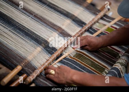 Ecuador, Quito, Paguche. Tahuantinsuyo Weaving Workshop. Traditional "back strap" weaving demonstration. Hand close up. Stock Photo