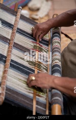 Ecuador, Quito, Paguche. Tahuantinsuyo Weaving Workshop. Traditional "back strap" weaving demonstration. Hand close up. Stock Photo