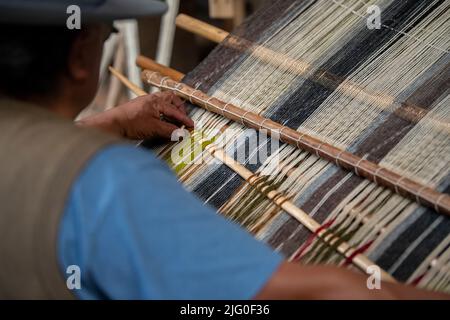 Ecuador, Quito, Paguche. Tahuantinsuyo Weaving Workshop. Traditional "back strap" weaving demonstration. Hand close up. Stock Photo