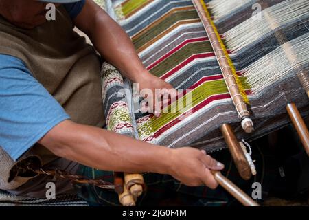 Ecuador, Quito, Paguche. Tahuantinsuyo Weaving Workshop. Traditional "back strap" weaving demonstration. Hand close up. Stock Photo