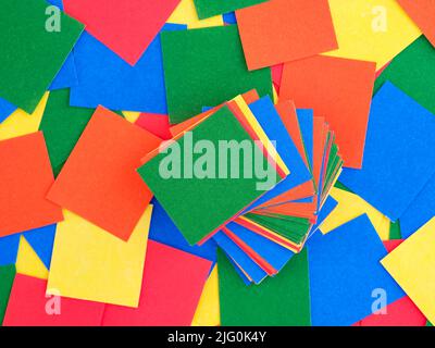 Multicolour pieces of paper in stack on a background of multicolour rectangular paper pieces. Full frame. Stock Photo