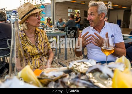 Florent Tarbouriech (r.) in conversation with food journalist Angela Berg at Le St Pierre Tarbouriech beach pavilion Stock Photo