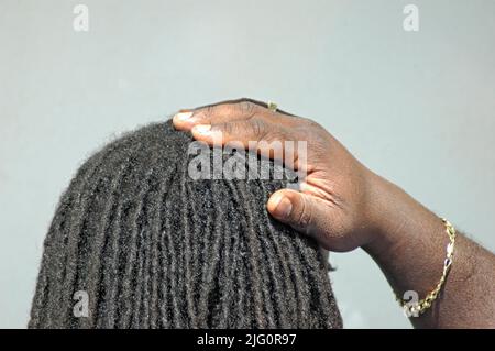 Dreadlocks in mans hair on his  head with his hand and copy and text space Stock Photo