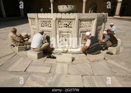 Kırkpınar (Turkish Oil Wrestling). Muslim men washing their feet before entering the mosque in the marble fountain in the courtyard of the Selimiye Mosque (Selimiye Camii) in Edirne, Turkey. The congregational prayer in the Selimiye Mosque marks the beginning of the 648th annual Kırkpınar Tournament on 2 July 2009. The annual tournament in Turkish oil wrestling traditionally starts with the Friday prayer (Jumu'ah) in the Selimiye Mosque designed by Ottoman imperial architect Mimar Sinan and built between 1568 and 1575. Ritual purification called wudu requiring Muslim people to wash their faces Stock Photo