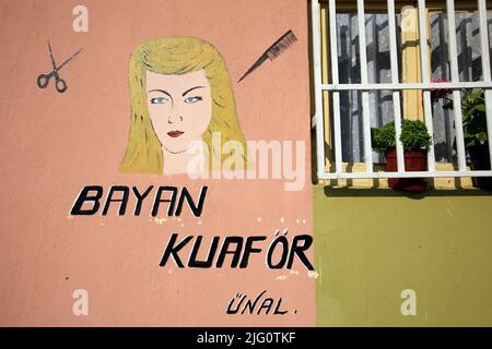 Female head with a new hairstyle depicted in the naïve sign of a women's hairdressing salon in Edirne, Turkey. Stock Photo