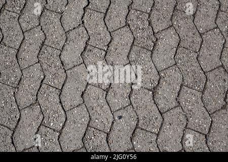 old concrete paver brick on a street surface. Made from concrete for road, path or driveways paving Stock Photo