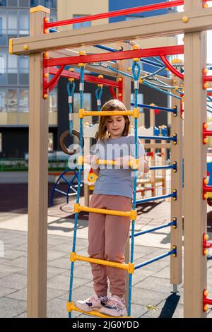 cute girl walks in the street and climbs Stock Photo