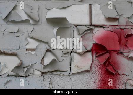 shabby burnt peeling paint on a brick wall Stock Photo