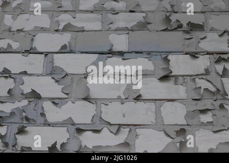 shabby burnt peeling paint on a brick wall Stock Photo
