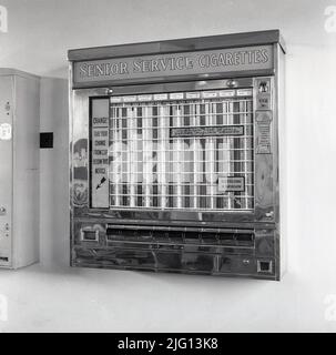 1950s, historical, a cigarette vending machine mounted on the wall at a Steel Works, Wales. UK. Available packets of Senior Service, Players & Woodbines cigarettes at a cost 2/- for 10.  Coin-operated, the machine also had a special coin slot, marked 'Florins Only'. A British coin, a florin was a two-shilling piece ( 2/-) that was issued until 1967 and had been in circulation from 1849. Stock Photo