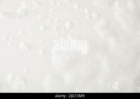 Foam texture on a white base with traces of soap and shower water detail. Top view. Horizontal composition. Stock Photo