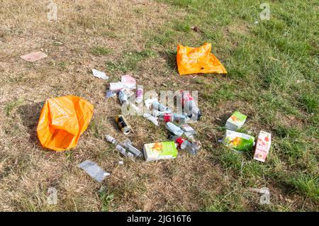 Empty alcohol and soft drink bottles left in Park green space Stock Photo