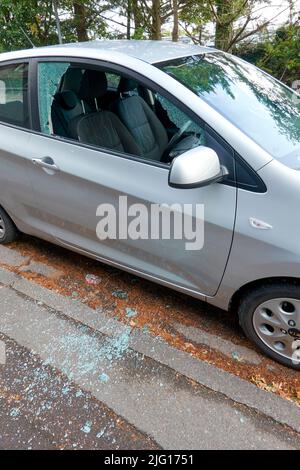 Car broken into by smashing the drivers side door window Stock Photo