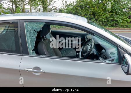 Car broken into by smashing the drivers side door window Stock Photo