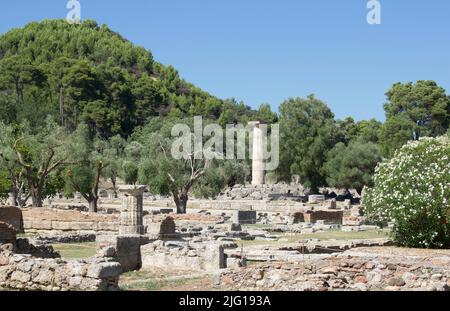 Archeological excavations at Ancient Olympia, Peloponnese. Landscape with ancient stones (columns), trees and rocks. Olympia, Greece Stock Photo