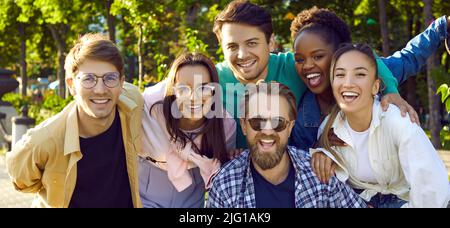 Happy young multiethnic friends men and woman smiling after summer street walk, group portrait Stock Photo