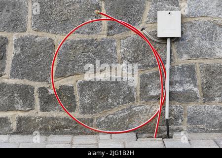 Broadband extension - fiber optic cable in front of the house wall Stock Photo