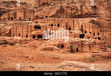 Simple dwelling ruins - cave like holes in stone wall - as seen in Petra, Jordan Stock Photo