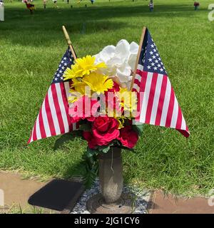 Cemetery Memorial Day flags and flowers in an urn, 2022. Stock Photo
