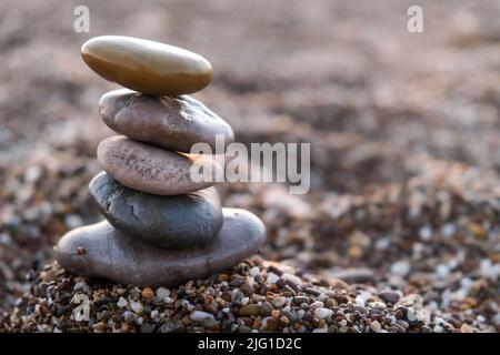 Pyramid of pebbles on the beach. Concept of zen, stability, harmony, balance and meditation, copy space. Stock Photo