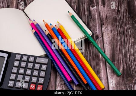 Various school supplies such as markers, colored pens and markers, notebook and eraser. On top of a wooden table. Back to school. Stock Photo