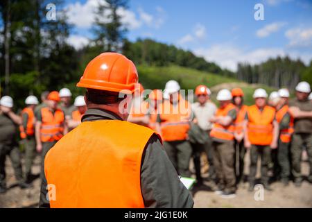 Helmet builder. Many construction workers helmet. Engineer team in hardhat for work. Worker group wearing vest, safety. Building concept. Architector Stock Photo