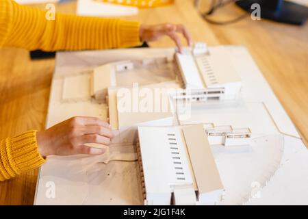 Cropped image of biracial female architect making architectural model in creative office Stock Photo