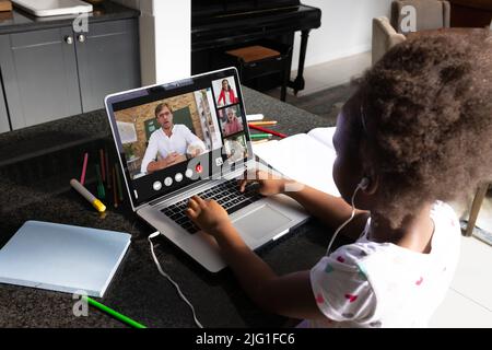 African american girl with afro hair listening to online lecture over headphones at home Stock Photo