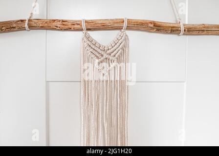 Part of wall decor made of woven threads in the style of macrame on white background Stock Photo