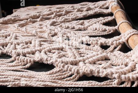 Hand woven black macrame with white beads hanging on wall Stock