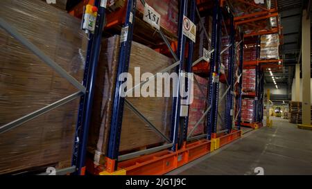 Moscow - Russia, 04.20.2022: Warehouse materials and metal shelves with goods inside cardbox boxes. Creative. The camera moves among the shelves with Stock Photo