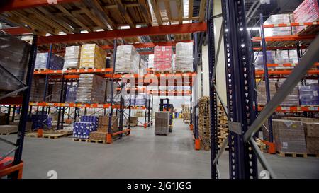 Moscow - Russia, 04.20.2022: Logistics business and shipping facility with forklifts to move boxes and parcels. Creative. Cardboard boxes inside a sto Stock Photo