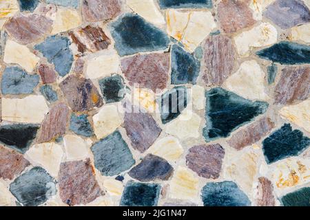 A stone wall made of multicolored stones. background blank. Stock Photo