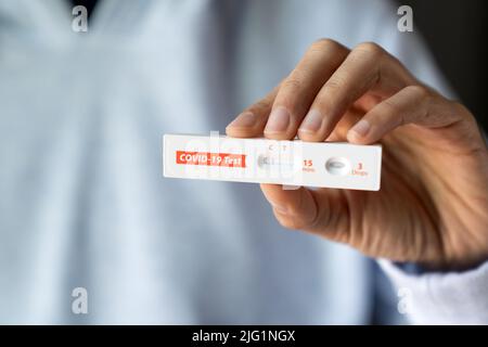 Woman is showing negative results on rapid antigen test kit for covid-19. Stock Photo